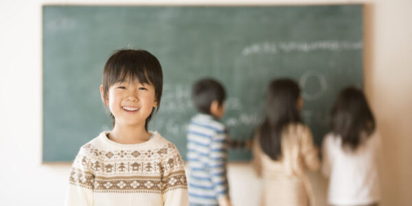 黒板の前で微笑む小学生の男の子